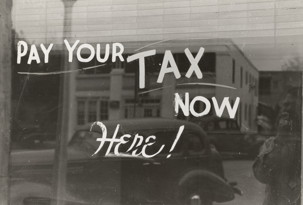 Un letrero que dice paga tus impuestos ahora aquí