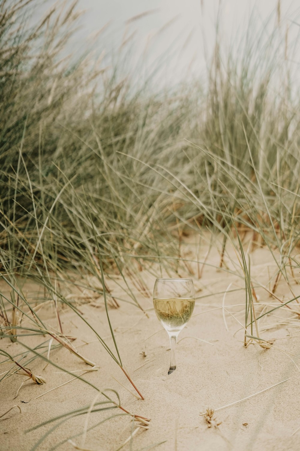 clear drinking glass on sand