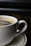 Close-up of a sleek industrial coffee cup with golden accents on a dark background.