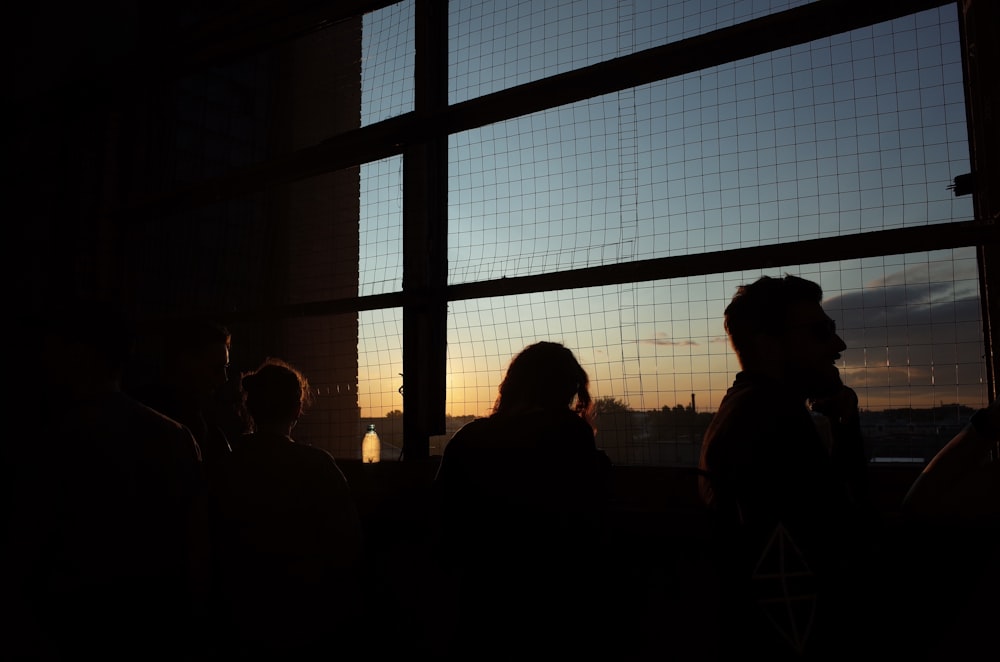 Un grupo de personas de pie frente a una ventana