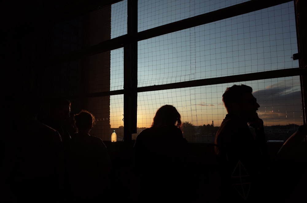 a group of people standing in front of a window