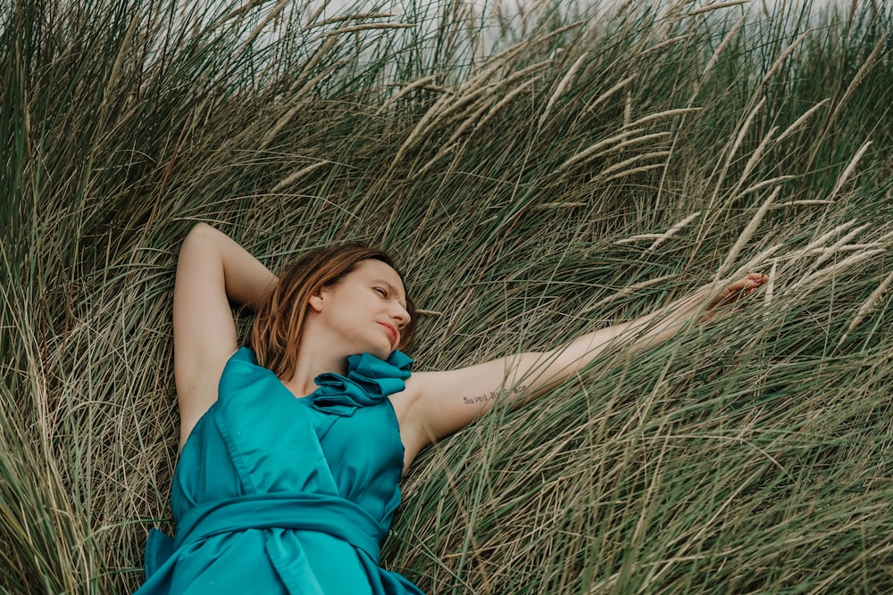 woman lying on green grass field