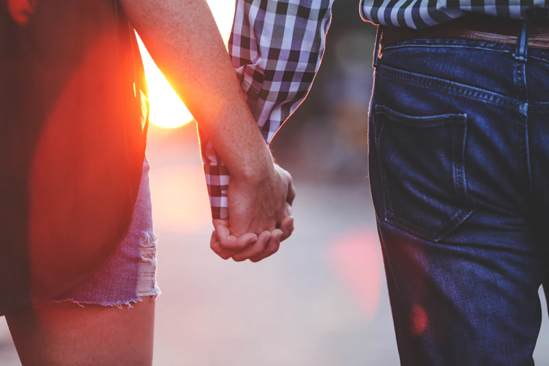Two people holding hands at sunrise