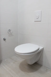 Elegant ADA-compliant toilet installed in a minimalist bathroom with gray tiles.