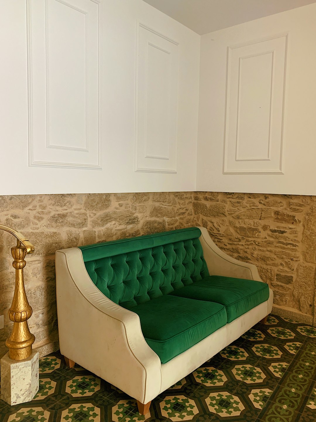 green tufted loveseat by the wall