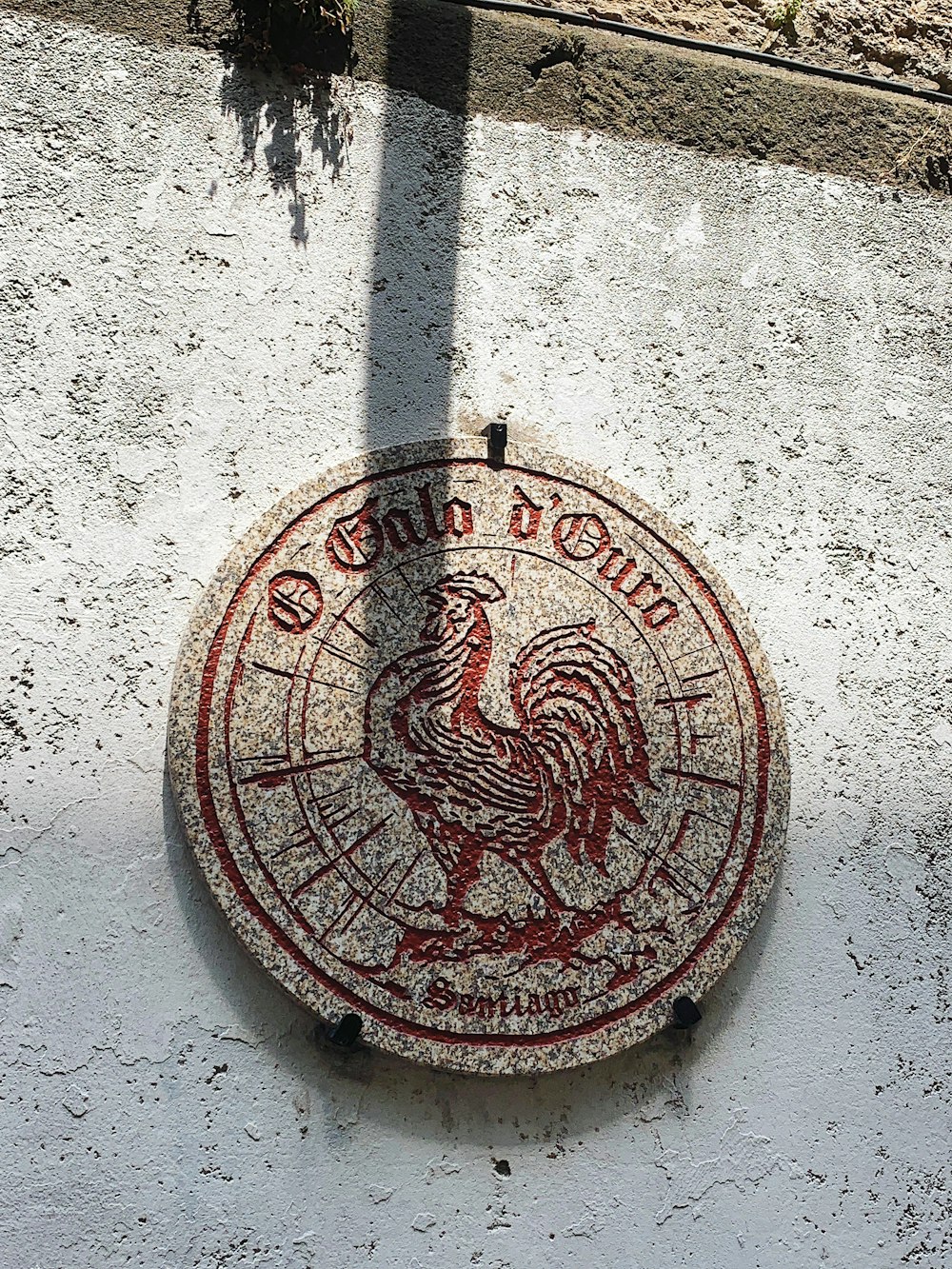 a sign on the side of a building with a rooster on it