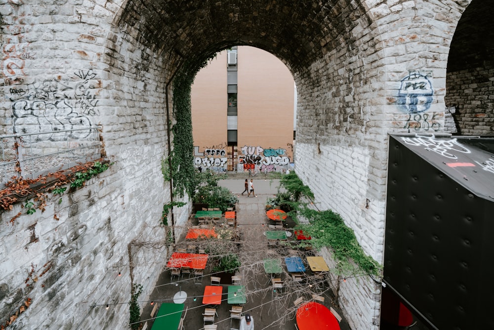 an alley way with tables and chairs and graffiti on the walls