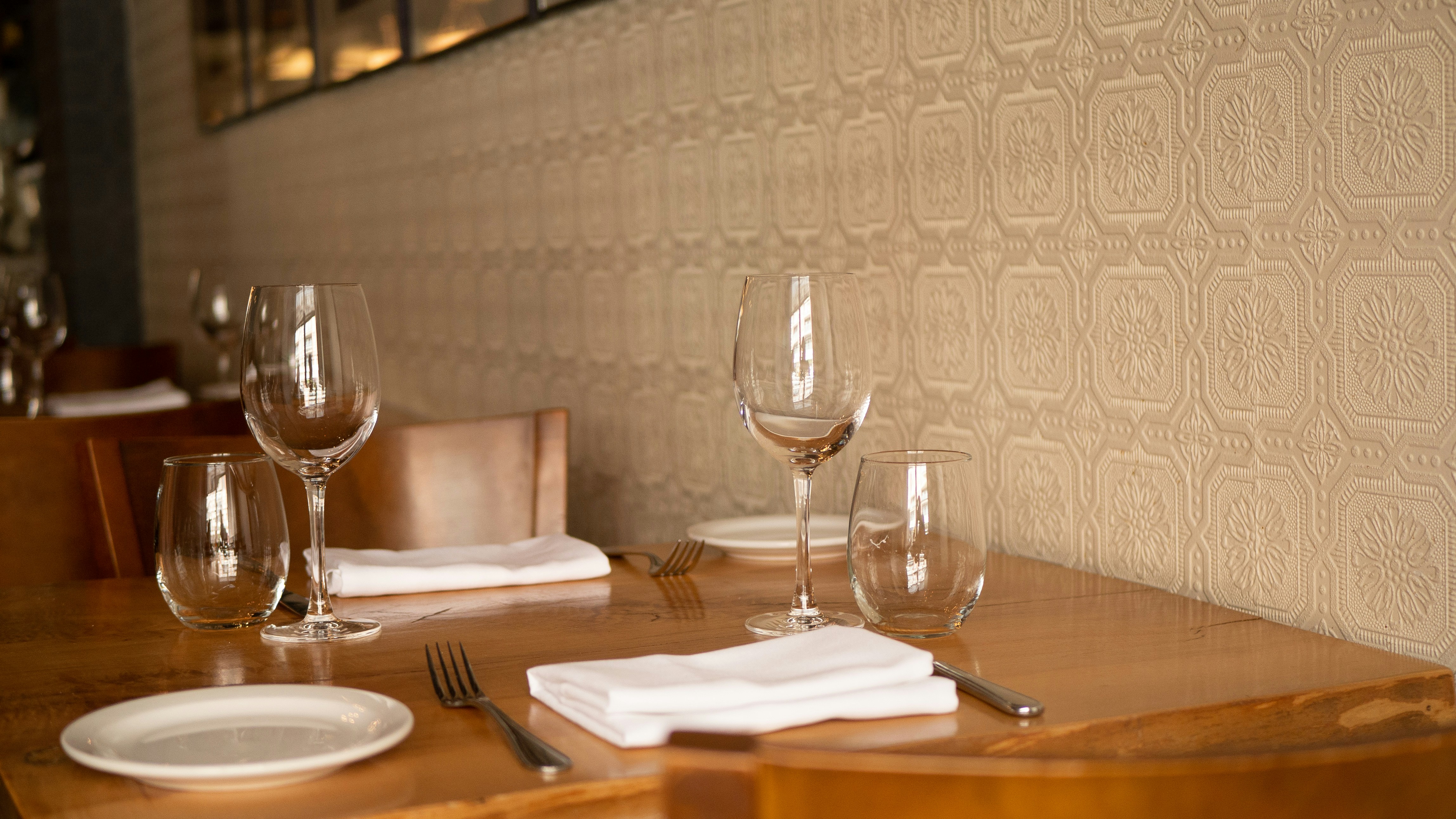 a wooden table topped with glasses of wine