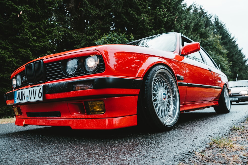 um carro vermelho estacionado na beira da estrada