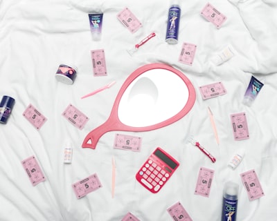 calculator, hand mirror, and toiletries in white textile