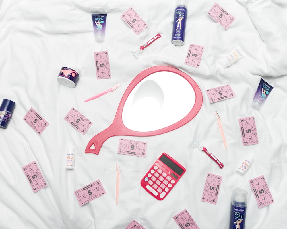 calculadora, espelho de mão e produtos de higiene pessoal em tecido branco