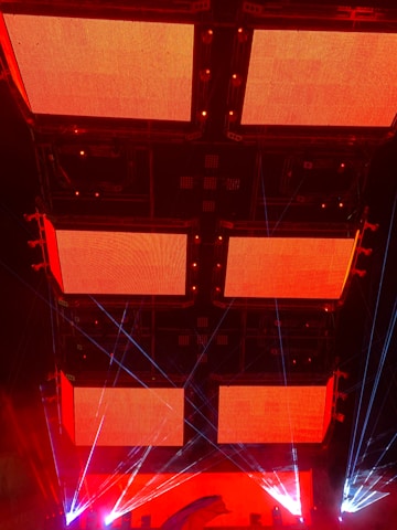 Brightly lit LED video wall displaying captivating visuals at a nighttime festival.