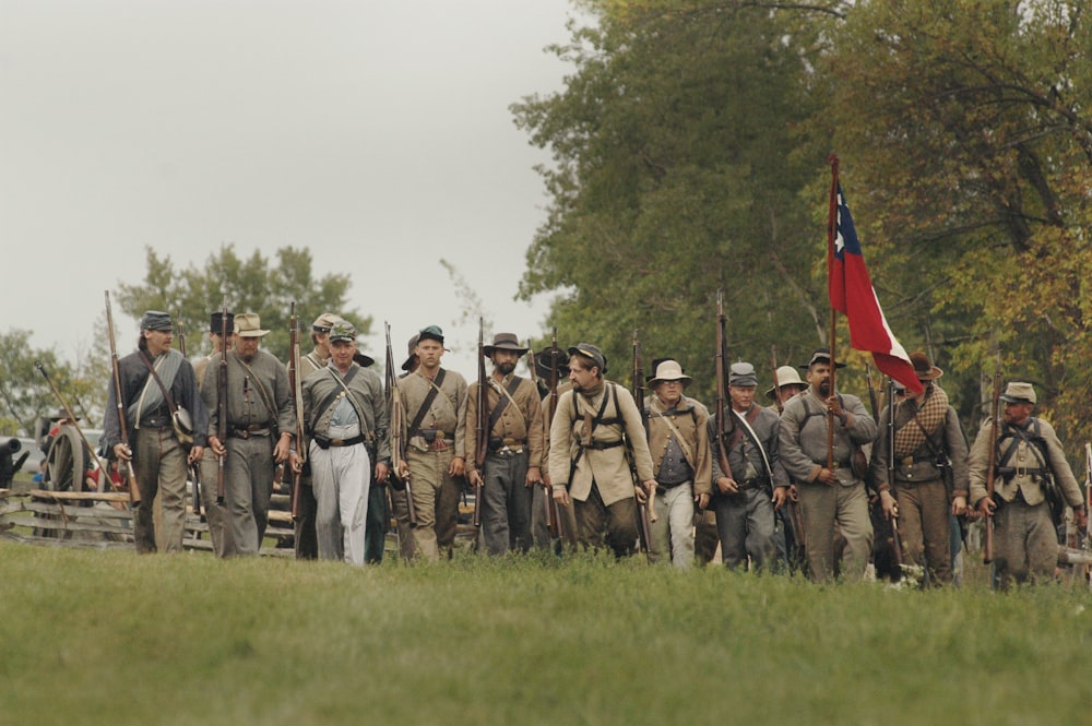 gruppo di uomini che tengono il fucile da caccia e la bandiera