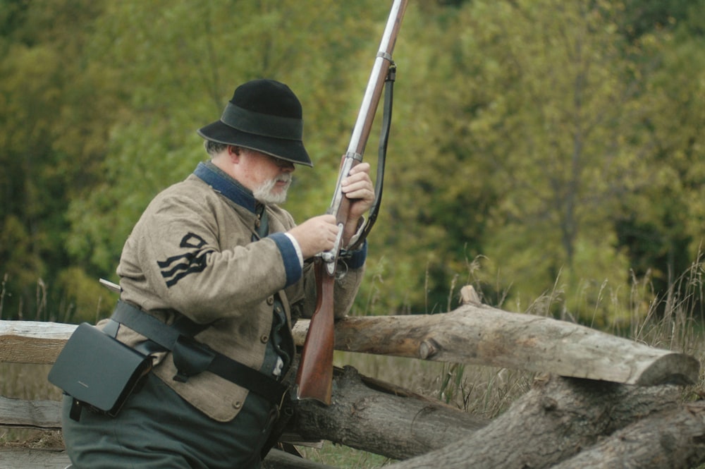 Hombre usando rifle marrón