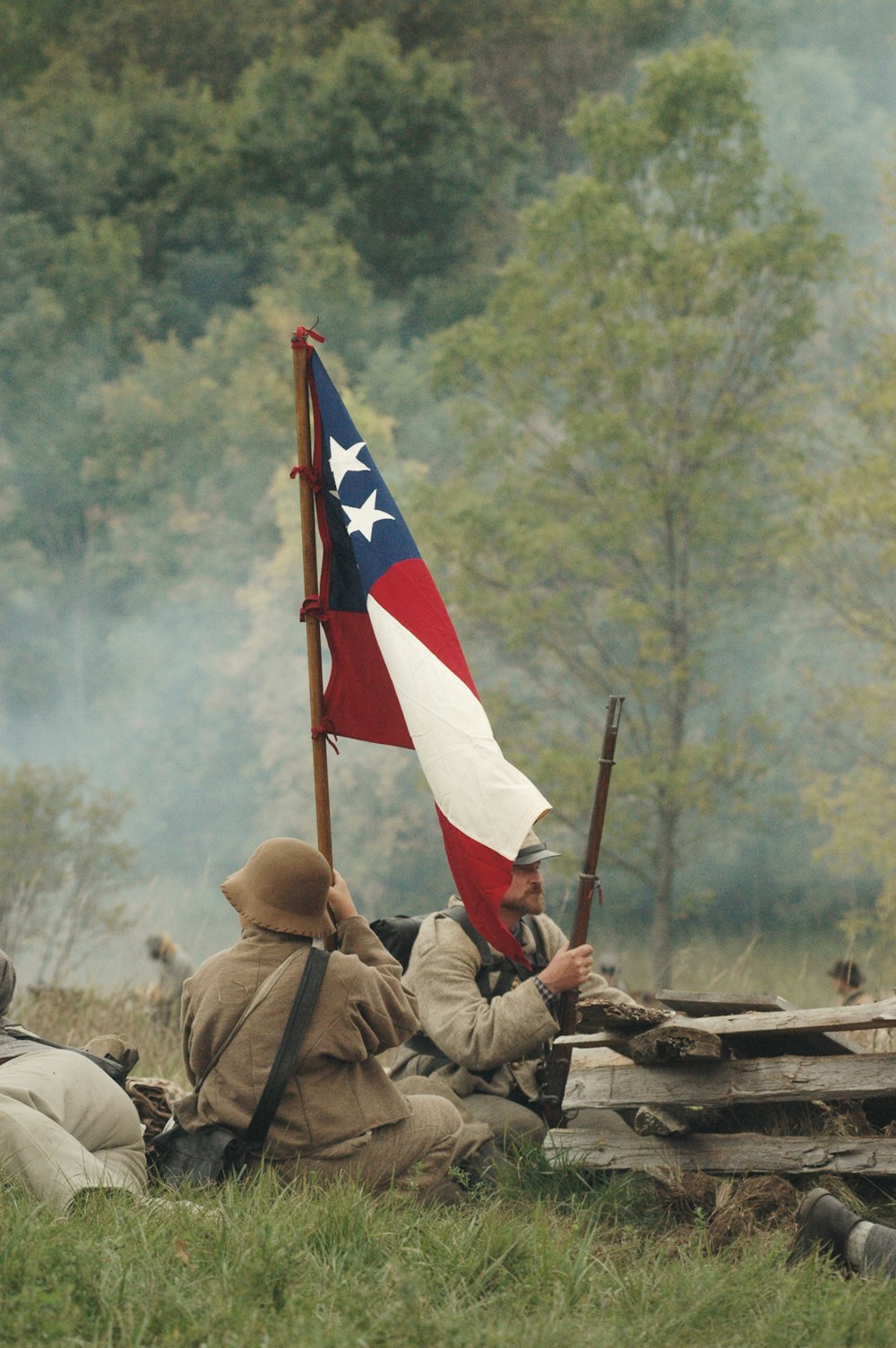 Soldats agitant un drapeau sur le champ de bataille
