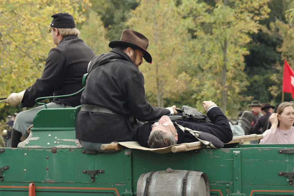 men lying on green vehicle