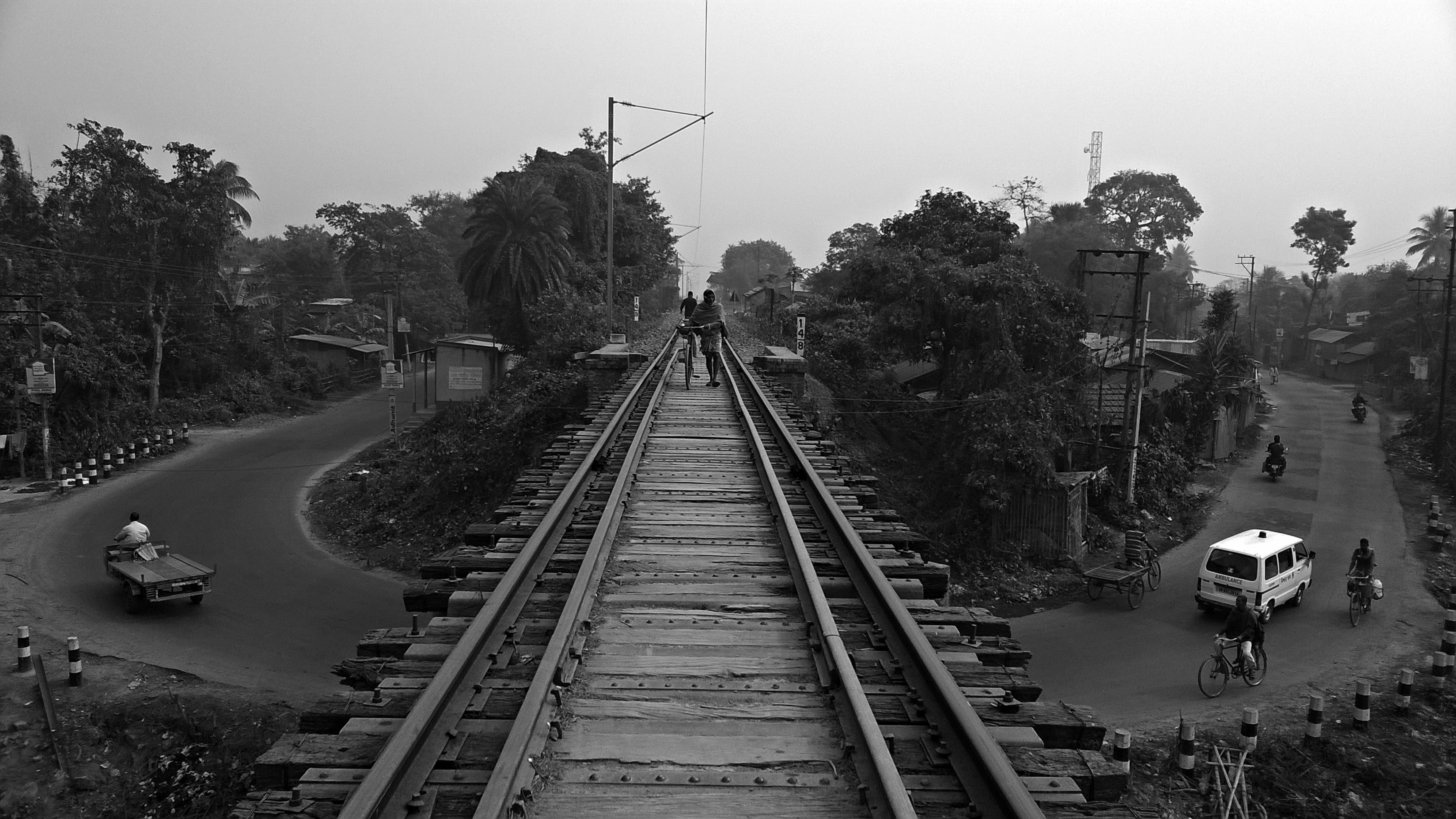 हावड़ा स्टेशन पर एक पुरानी ट्रेन के पास यात्रियों की भीड़ का दृश्य, जिसमें प्लेटफार्म का एक हिस्सा दिखाया गया है और लोग चढ़ने के लिए संघर्ष कर रहे हैं।
