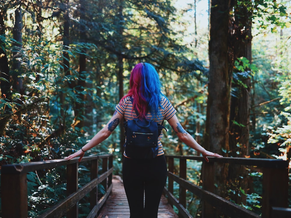 woman standing on brown wooden bridge