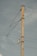 A tall wooden utility pole is standing against a cloudy sky. The pole has several electrical wires attached to it, and there is a black and white sign with the letter 'R' mounted on the side of the pole.