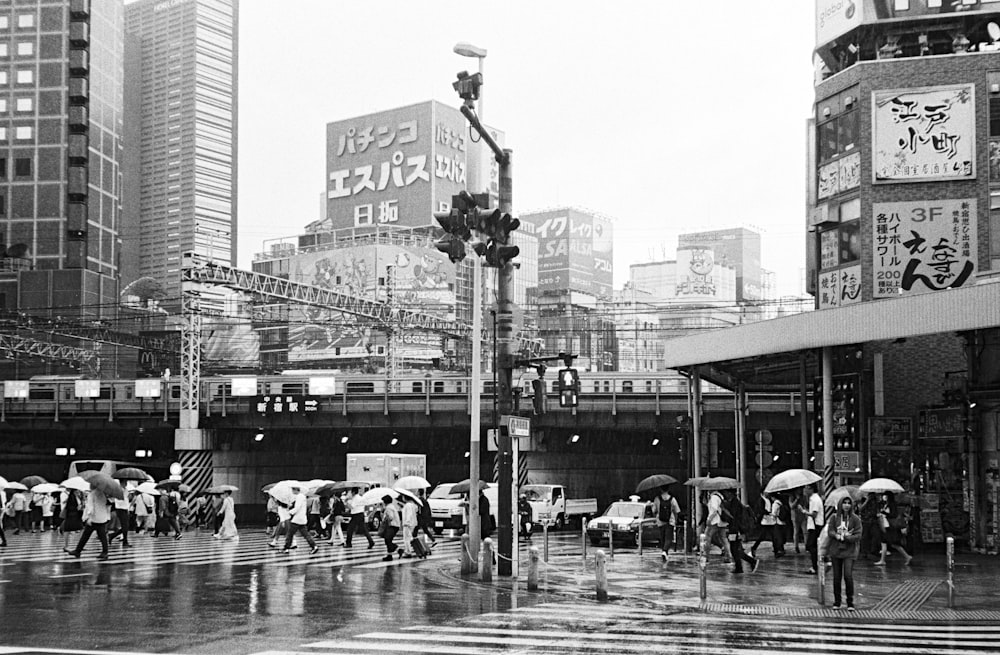 grayscale photography of people crossing on pedestrian lane