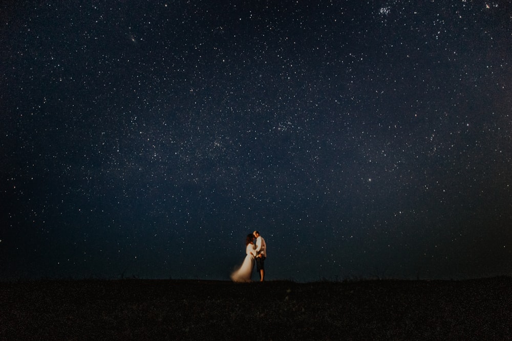 Hombre y mujer abrazándose en la noche estrellada