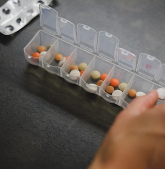 person about to pick medicine from medicine organizer