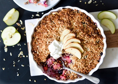 A cast iron skillet showcasing warm apple crisp with a crunchy oat topping and caramelized apples peeking through.