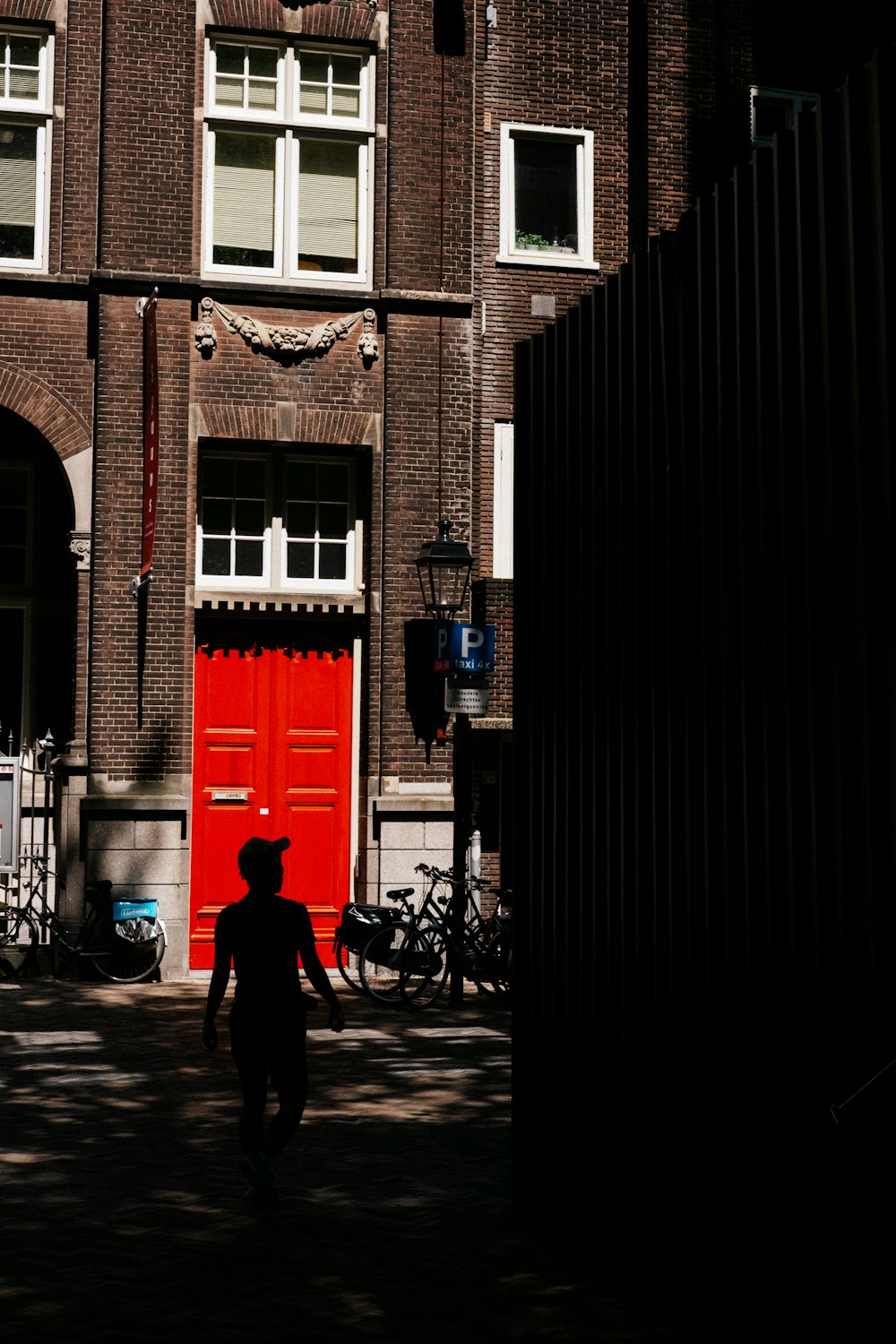 silhouette of child in front of brown concrete building