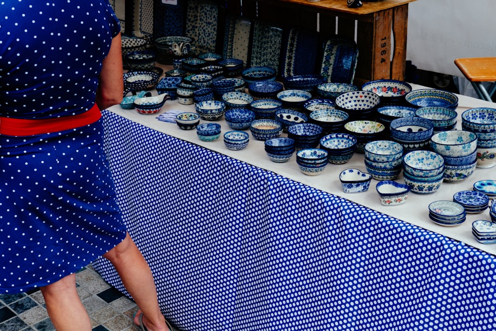 woman standing beside dinnerware set