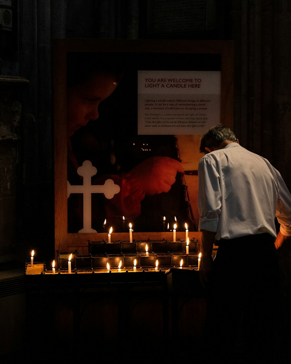 man standing in front of candles