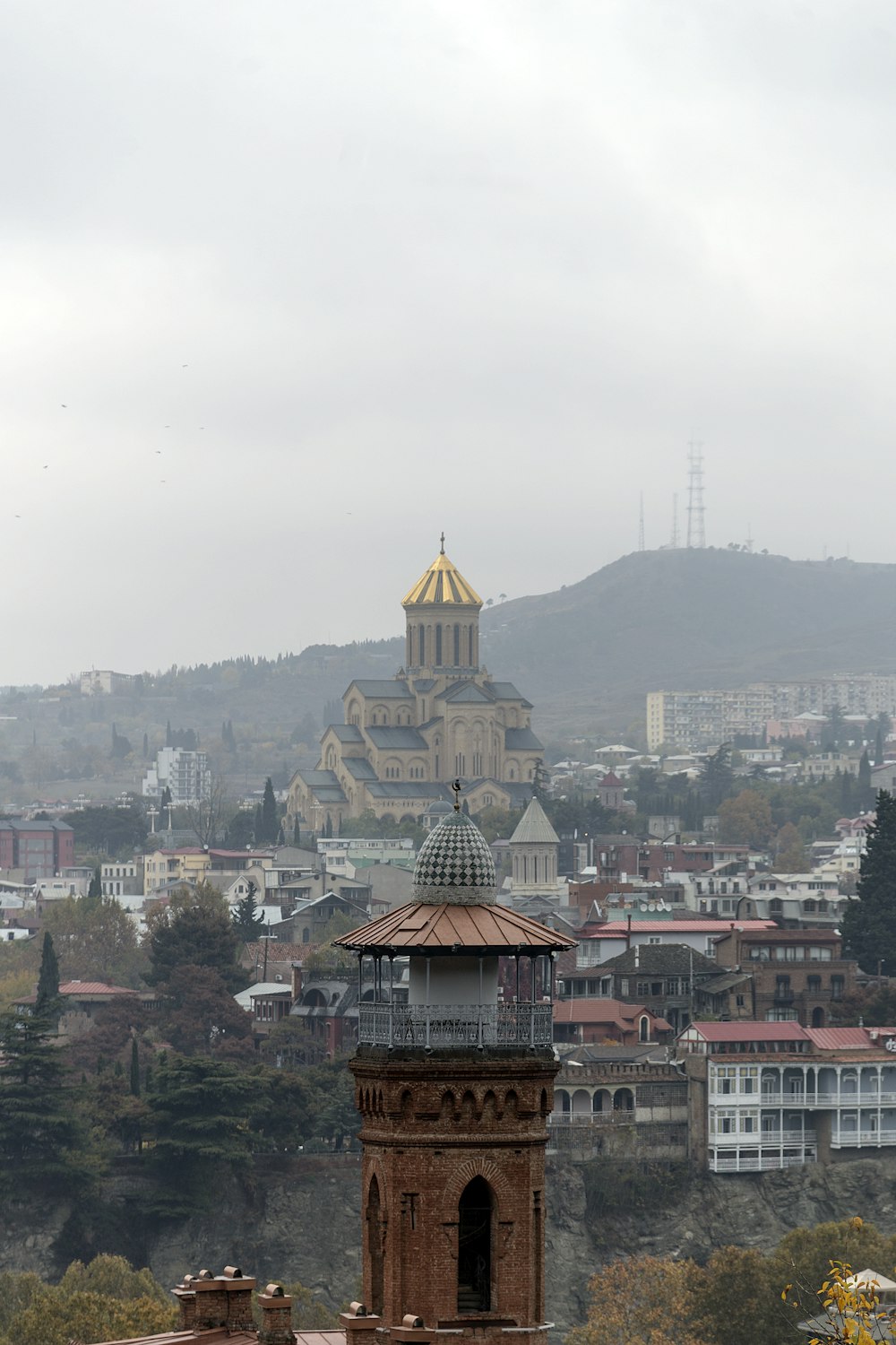 brown and white painted tower overlooking city buildings