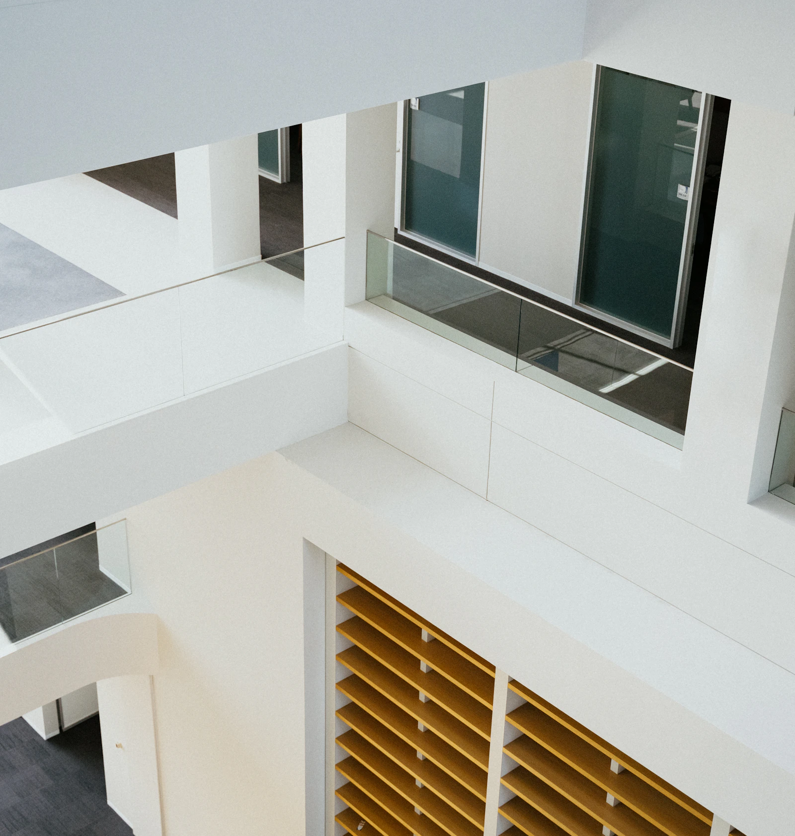 Quiet white atrium with glass railings and natural light