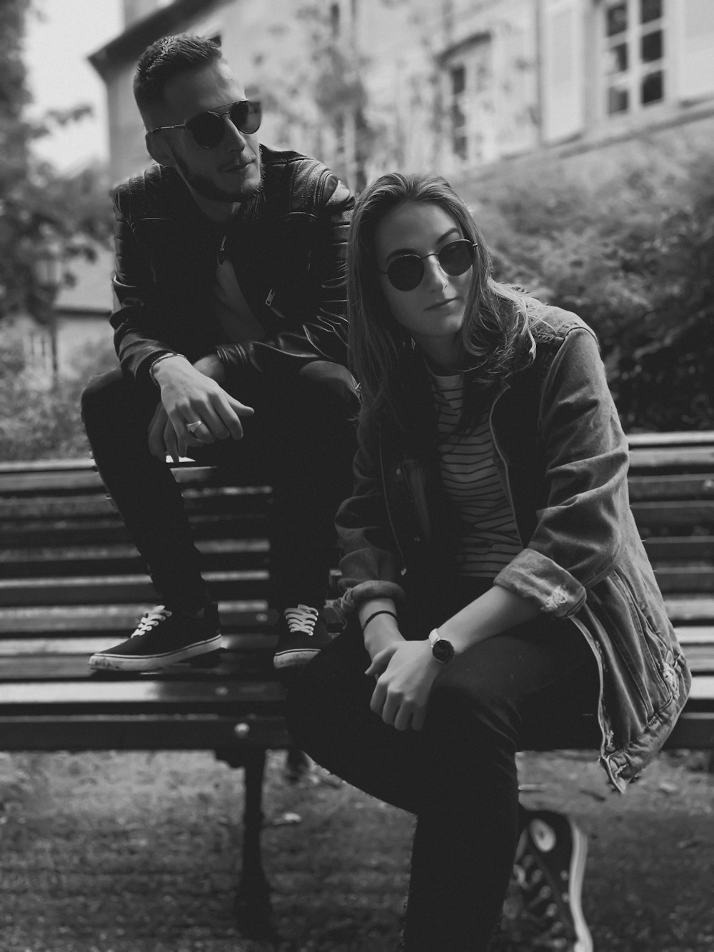 grayscale photo of a man and a woman on a bench