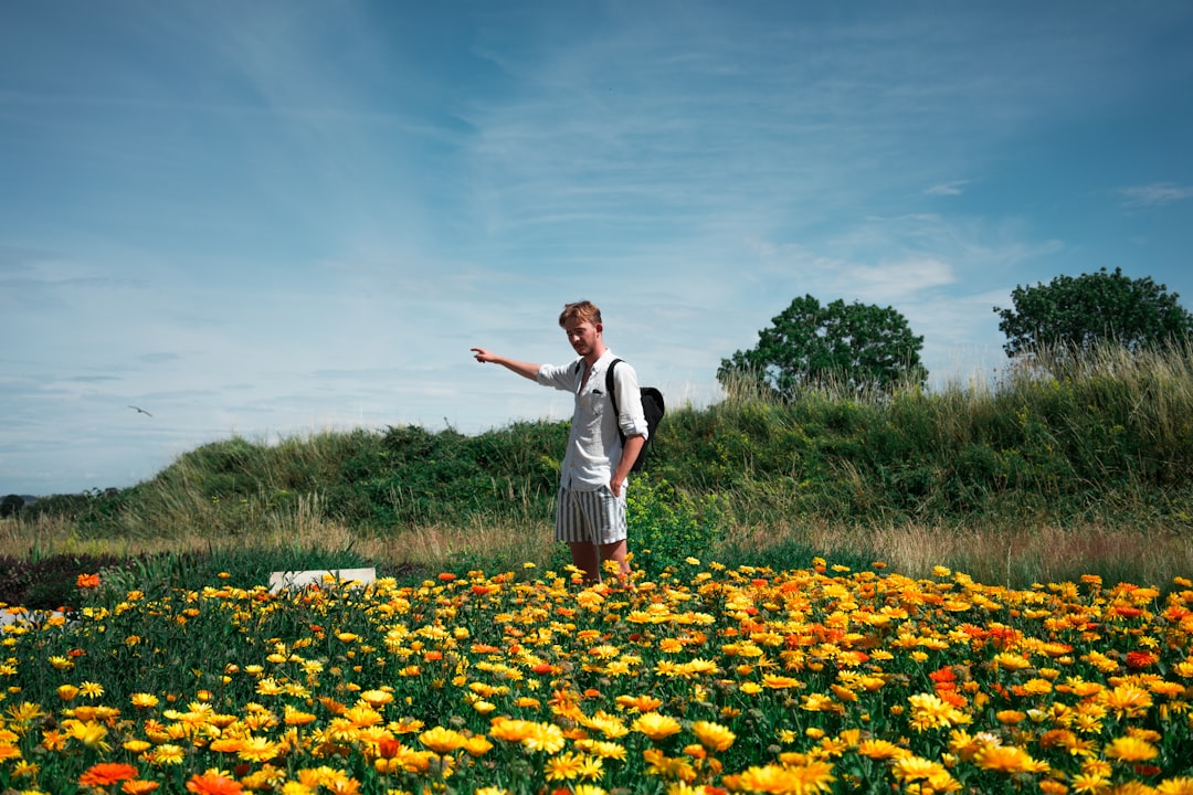 man standing on flower field at daytime