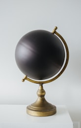 a black globe sitting on top of a white table