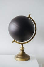 a black globe sitting on top of a white table