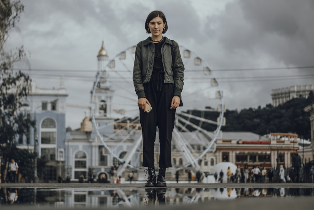 woman standing on the ground with ferres wheel at the back