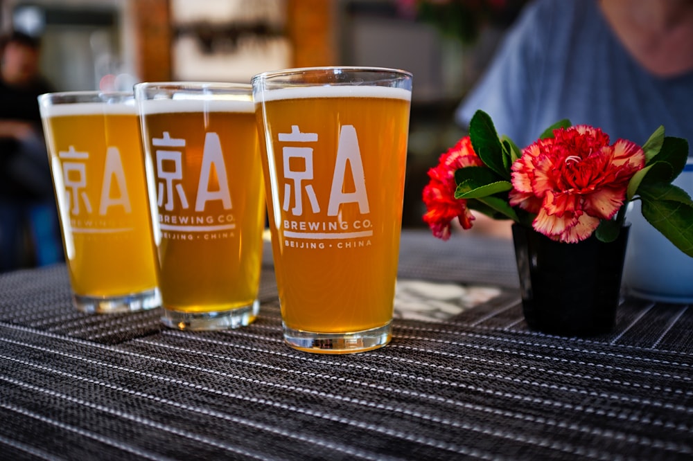 three pint glasses with beers on table