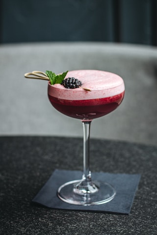 fancy red cocktail and glass, blackberry and mint garnish