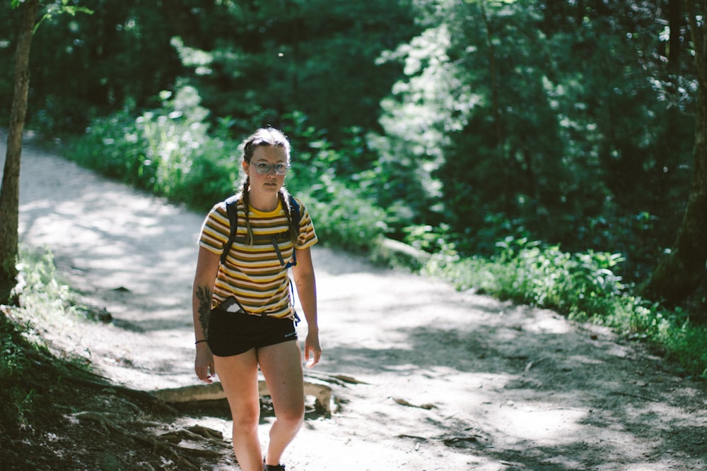 woman on pathway near trees