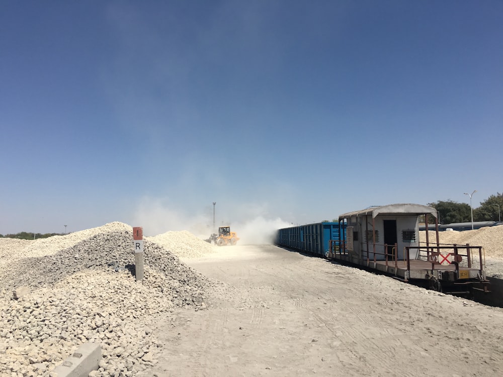 Container blu vicino al campo sotto cieli blu e bianchi