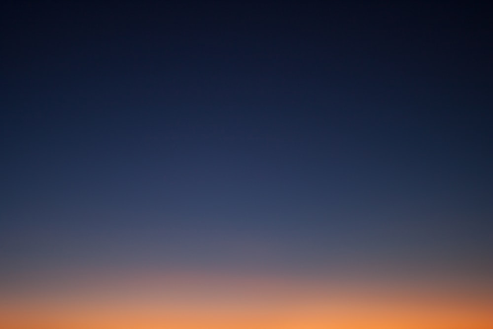 the sun is setting over the horizon of a body of water