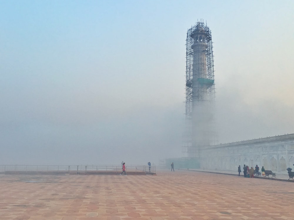 Torre del faro gris rodeada de humo blanco