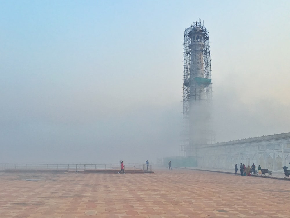 gray lighthouse tower surrounded by white smoke