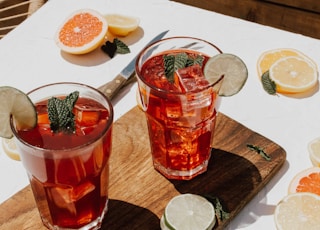 two clear drinking glasses with filled red liquid