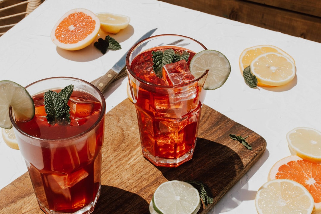 two clear drinking glasses with filled red liquid,