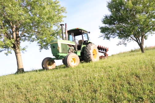 A tractor being carefully cleaned outdoors in a rural setting.