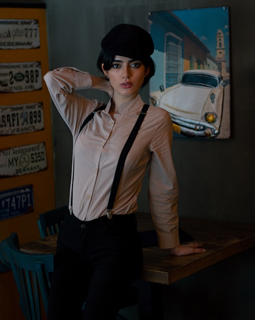 A vibrant airbrushed sweatshirt, hat, and license plate displayed on a rustic wooden table.