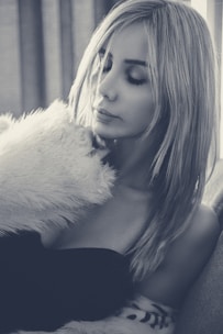 Close-up of a luxurious satin sleep bonnet in soft blush pink, resting gently on a plush white pillow.