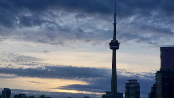 A vibrant skyline view of Toronto, Canada at sunset with the CN Tower illuminated.